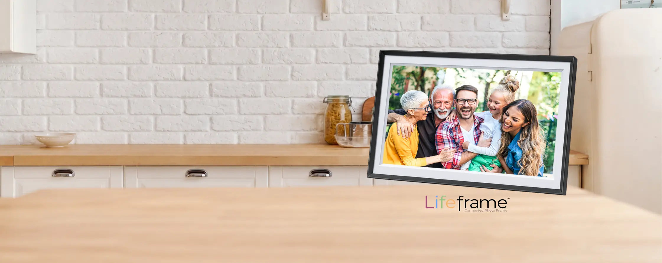 Lifeframe digital photo frame displaying a multigenerational family photo on a kitchen bench.
