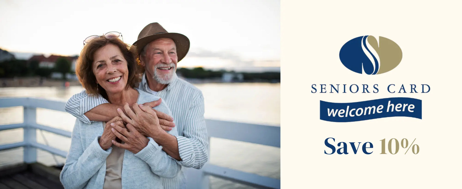 Smiling older couple beside Seniors Card welcome here sign with 10% discount offer.